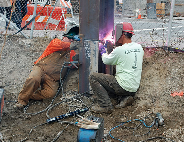 Two UBC Pile Drivers welding a steel girder